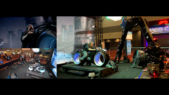 A person rides a futuristic motorcycle simulator with glowing wheels, attached to a robotic arm at a trade show.