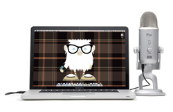 A silver laptop displaying a cartoon character on a plaid background next to a silver condenser microphone.