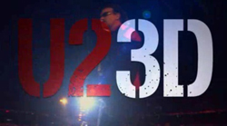 Large red and white U2 3D text overlaid on a dark concert stage with bright lights.