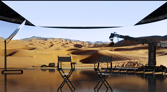 A film set with two director chairs and a camera crane overlooking sand dunes under a clear sky.