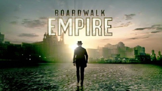 A man in a suit and hat walks toward a bright sun over a city skyline with the text Boardwalk Empire.
