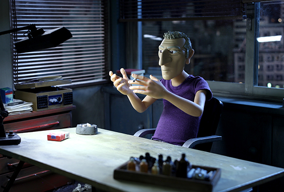 A claymation man in a purple shirt sits at a desk in a dimly lit office near a window.