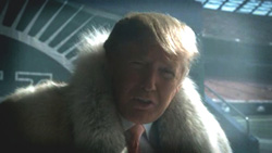 A man with blonde hair wearing a large, light-colored fur coat.