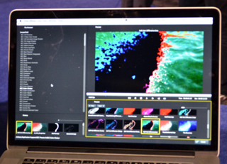 A laptop screen showing a video editing program with a colorful, abstract video clip on the timeline and preview.