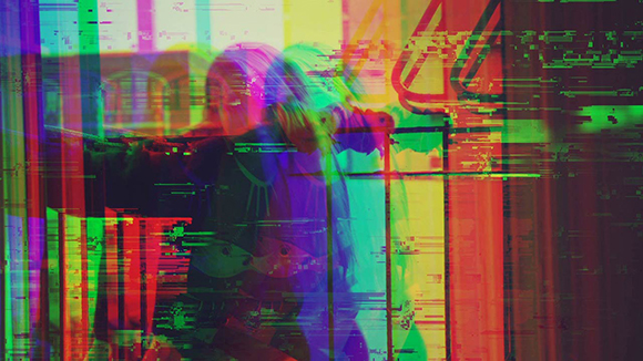 A person playing a violin obscured by colorful, horizontal digital glitch distortions.
