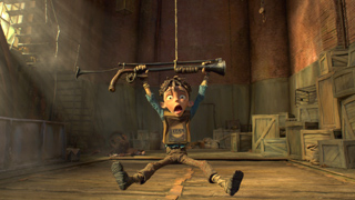 Animated boy with wide eyes and open mouth holding a large cannon over his head in a dusty warehouse.