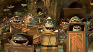 Several small, wide-eyed animated creatures emerging from cardboard boxes in a dimly lit cave.