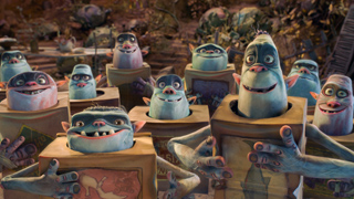 Animated blue creatures with large eyes emerging from cardboard boxes in a cluttered setting.