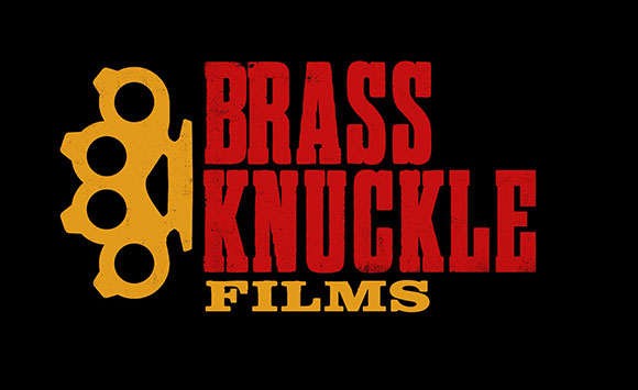 Red and gold logo for Brass Knuckle Films featuring a brass knuckle icon on a black background.