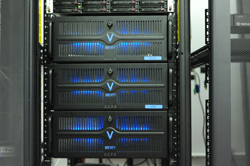 Three black server units stacked vertically in a rack, featuring glowing blue lights behind horizontal vents.