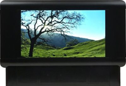 A digital screen displaying a landscape of a lone tree on a grassy hill under a bright blue sky.