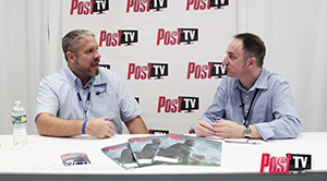 Two men in light blue shirts sit at a white table in front of a Post TV logo backdrop.