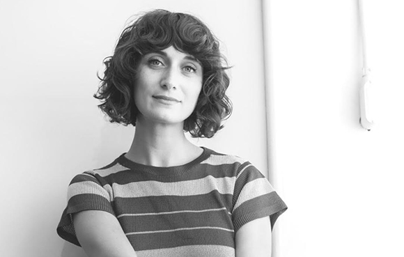 Black and white portrait of a woman with wavy, chin-length hair wearing a striped shirt.