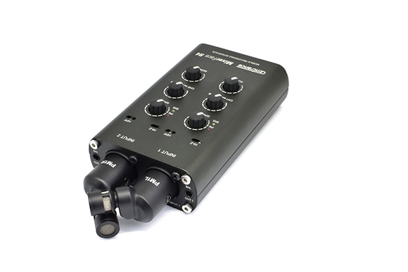 A black Emmanace Mixerface i4 audio interface with several control knobs and two microphones plugged in.