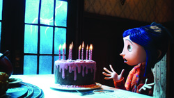 A blue-haired animated girl stares in surprise at a lit birthday cake in a dimly lit room.