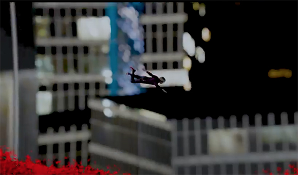 A person mid-air performing a flip in front of a blurred city building at night.