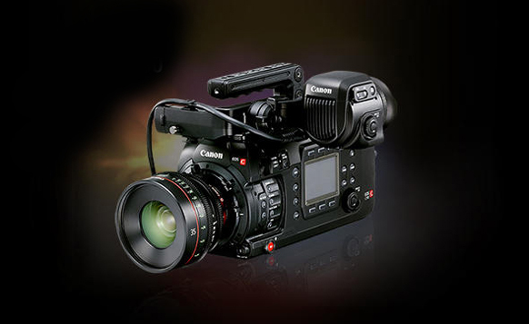Black Canon cinema camera with a large lens and handle, set against a dark background.