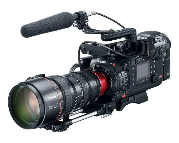 A professional Canon EOS C series cinema camera with a large zoom lens and a shotgun microphone attached.
