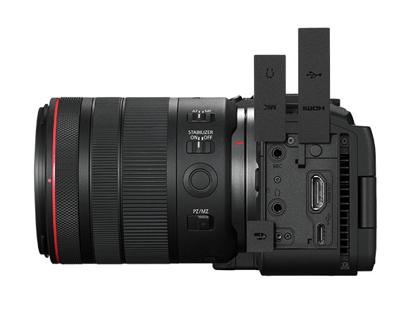 Side profile of a black professional camera with a large lens and open protective flaps for ports.