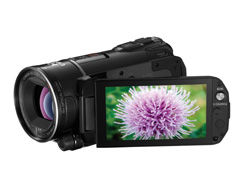 A black digital video camera with a screen showing a close-up of a purple flower.