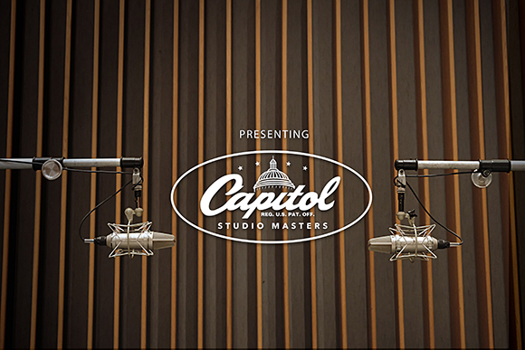 Capitol Studio Masters logo flanked by two condenser microphones on a vertical wood slat wall.
