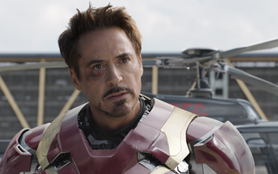 A man with dark hair and facial hair wearing red and gold metallic armor.