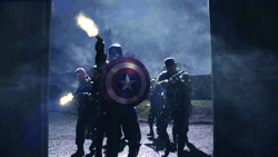 Soldiers advancing through a doorway, one carrying a large red, white, and blue star-patterned shield.