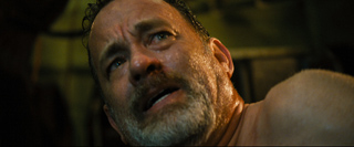 Close-up of a sweating, bearded man looking upward with a pained or worried expression.