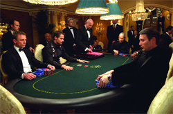 Men in tuxedos and formal wear seated around a green gambling table in a luxurious room.