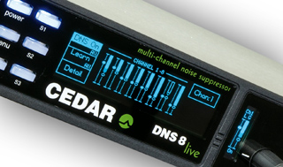A digital display on a black audio device showing blue channel levels and status text.