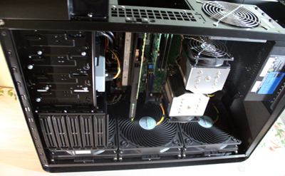 An open black computer tower showing internal components like fans, circuit boards, and cooling systems.