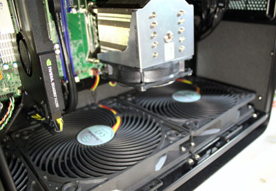 Close-up of a CPU heatsink and two large intake fans inside a black computer chassis.