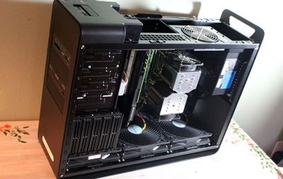 An open black computer case revealing internal hardware, fans, and circuit boards.