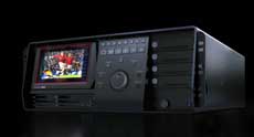 A black electronic control unit with a small screen showing a soccer game and various buttons.