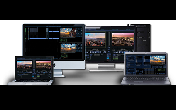 Multiple desktop monitors and laptops displaying professional video editing interfaces and timelines.