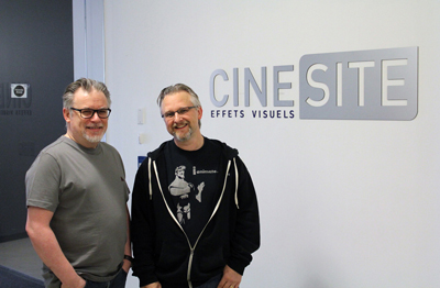 Two men smiling while standing in front of a white wall with the Cinesite logo.