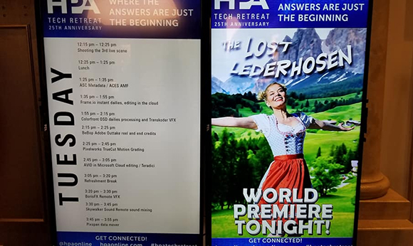 Two digital screens displaying event schedules and a movie advertisement for The Lost Lederhosen.