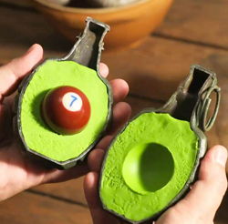 Hands holding two green avocado-shaped containers, one with a red billiard ball inside.