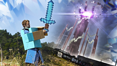 A person in a blocky blue and tan costume holds a pixelated sword before a tall, dark structure.