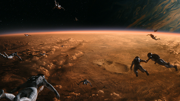 Multiple astronauts floating in space above a vast, reddish-orange planet with clouds and craters.