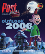 An elf in a green tunic and red hat stands in a snowy village at night. Santa's sleigh is in the sky.