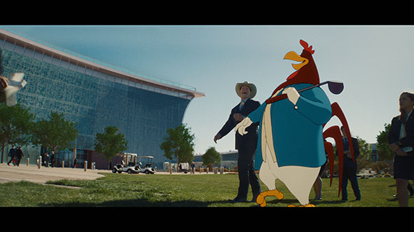 A large animated rooster in a blue suit stands on a lawn before a modern glass building and people.