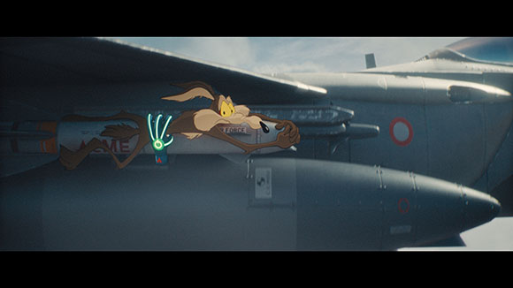 A cartoon rabbit clings to a missile attached to the underside of a military fighter jet.