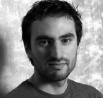 Black and white headshot of a man with dark hair and a short beard looking toward the camera.