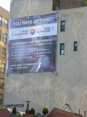 A large purple banner on a building wall reading 'YOU HAVE OPTIONS!' and promoting Mega Playgrounds.