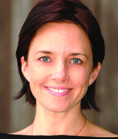 A smiling woman with short dark hair and blue eyes looking directly at the camera.