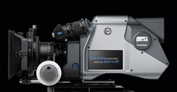 A silver and black professional digital cinema camera with a small display screen.