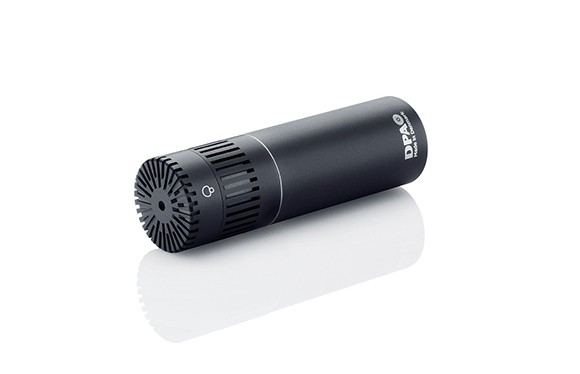 A black cylindrical DPA microphone angled on a reflective white surface.