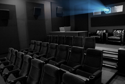 Rows of black theater seats in a dark room with a blue light beam from a projector.