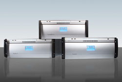 Three silver rectangular electronic devices stacked in a pyramid formation on a dark reflective surface.
